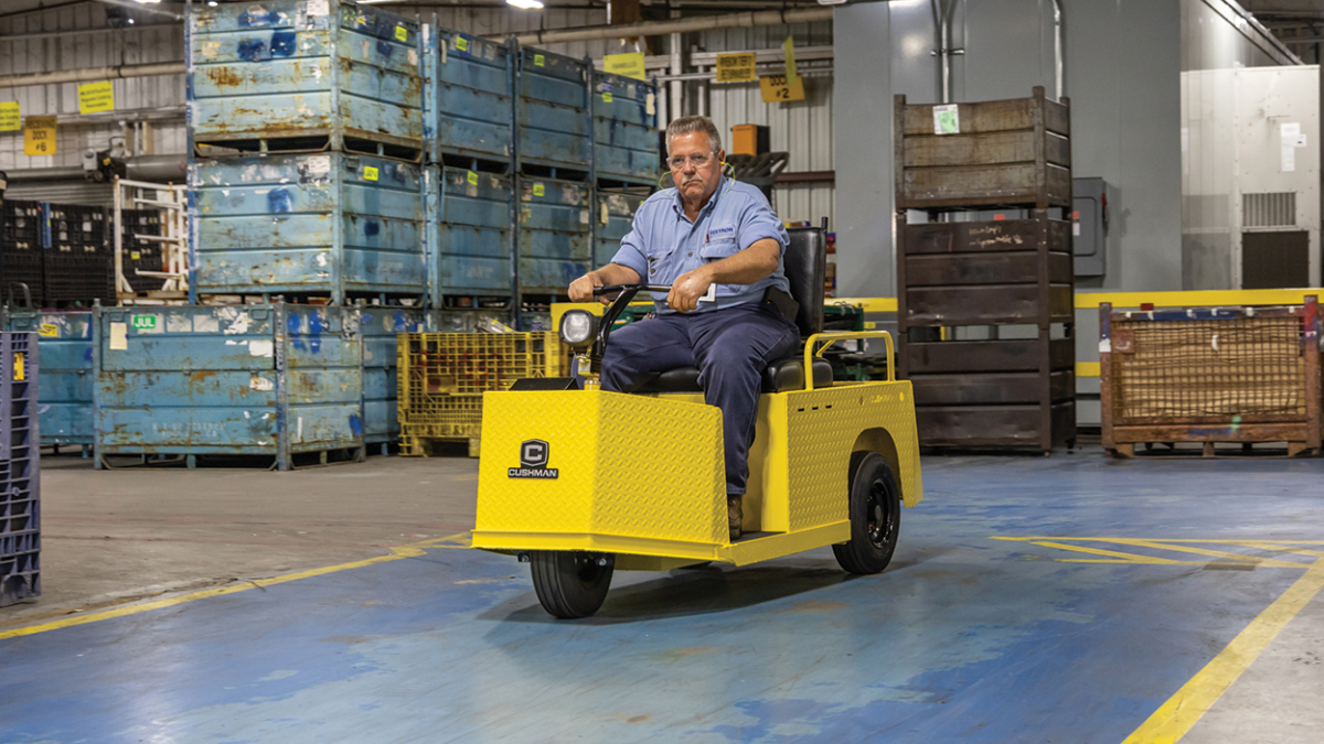 Cushman Minute Miser riding in a industrial facility